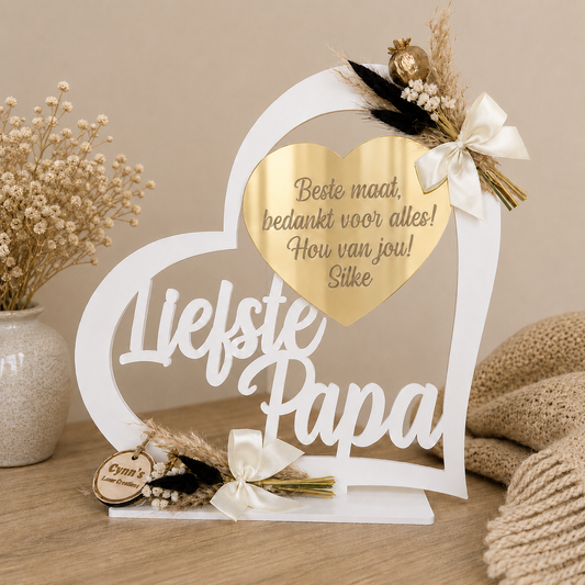 Gepersonaliseerde houten hartstaander met naam in het wit met gouden tinten en droogbloemetjes
